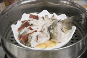 將鱸魚成花狀擺好，將火腿切片放入各縫隙中，放入鍋中隔水蒸12分鐘拿出，撒上蔥花即可。
