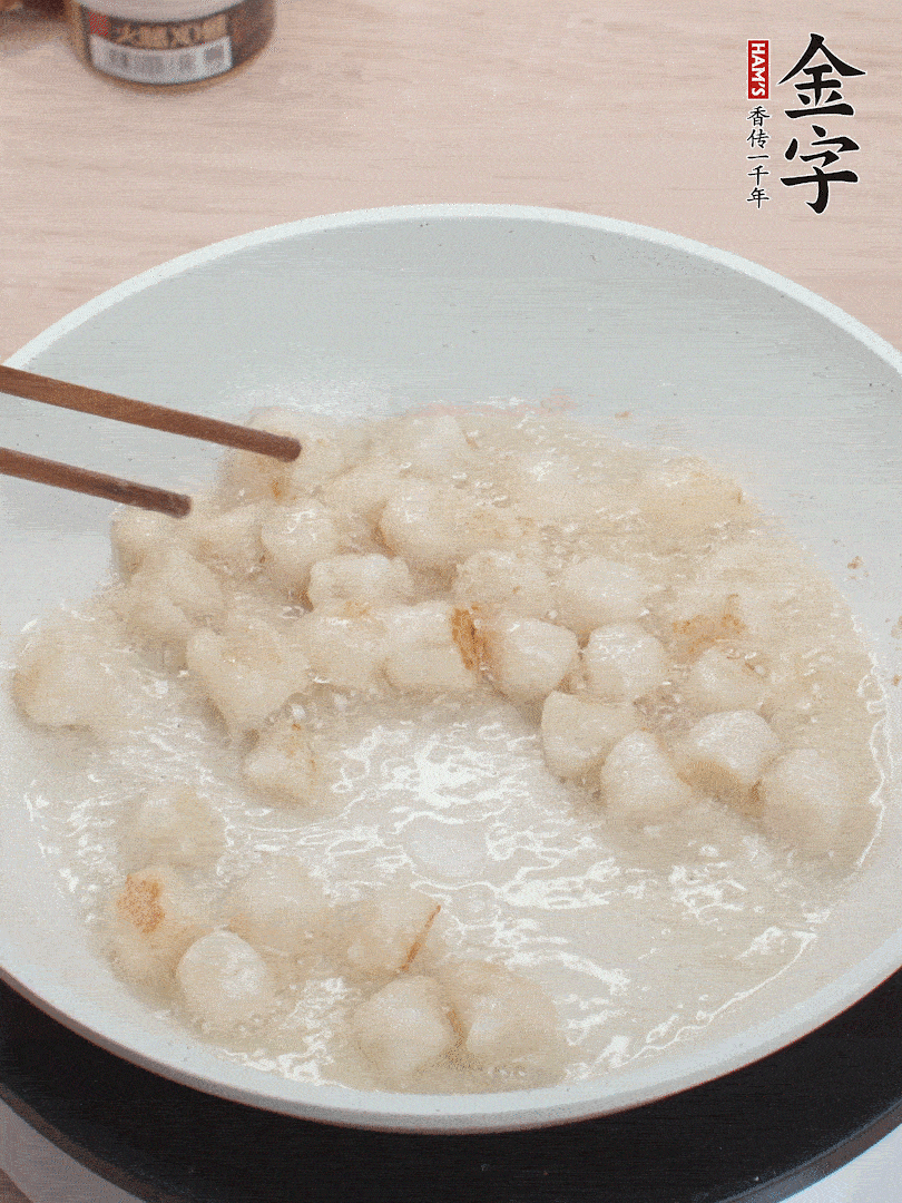 油溫4成熱，鮮貝蘸干淀粉下鍋煎，一面微黃后翻面。