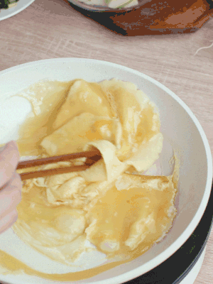 油6成熱時，下雞蛋液，邊緣凝固時翻拌成塊狀。