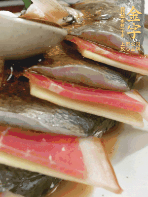 魚肚中塞蔥結(jié)、火腿片，魚身上碼放姜片、火腿片，倒入混合的料汁。
