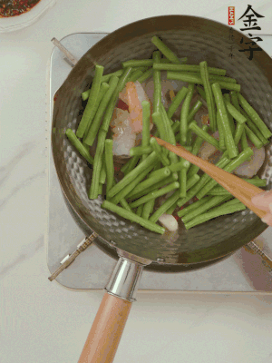 下掰好的缸豆段翻炒，略燜煮。