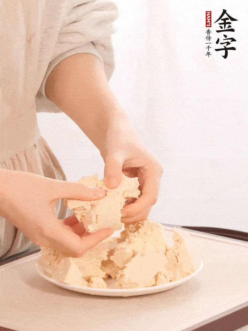 老豆腐用手掰成塊。