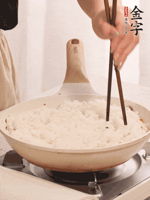 把瀝干水分的米飯均勻鋪在上面，筷子戳幾個洞，以便透氣，轉(zhuǎn)小火蓋上蓋子燜至水分收干，大概10分鐘。