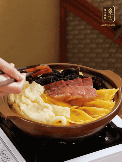 砂鍋底部鋪上娃娃菜，依次擺上肉皮、蛋餃、黑木耳、火腿